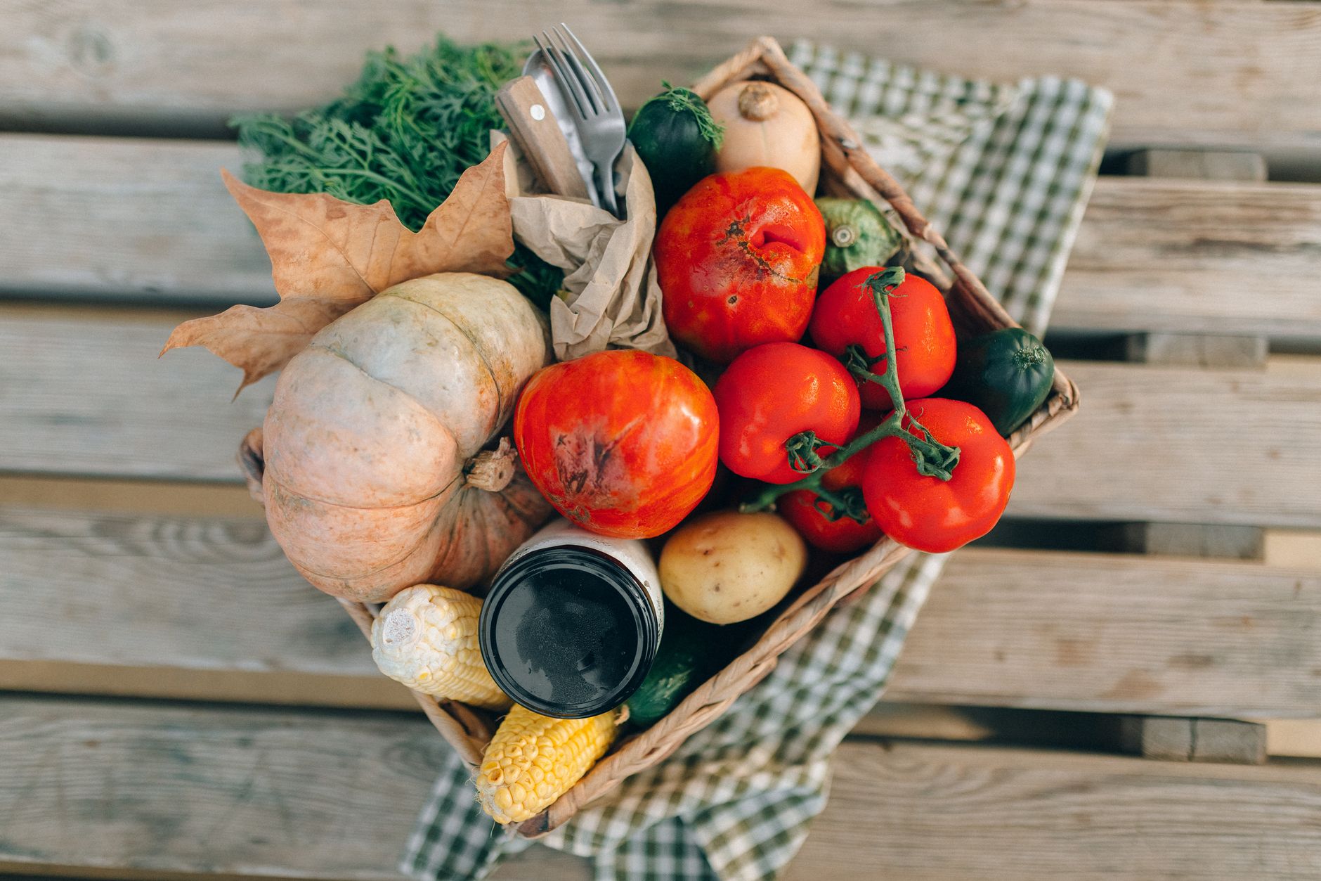 A top-down view of a basket filled with fresh vegetables and produce